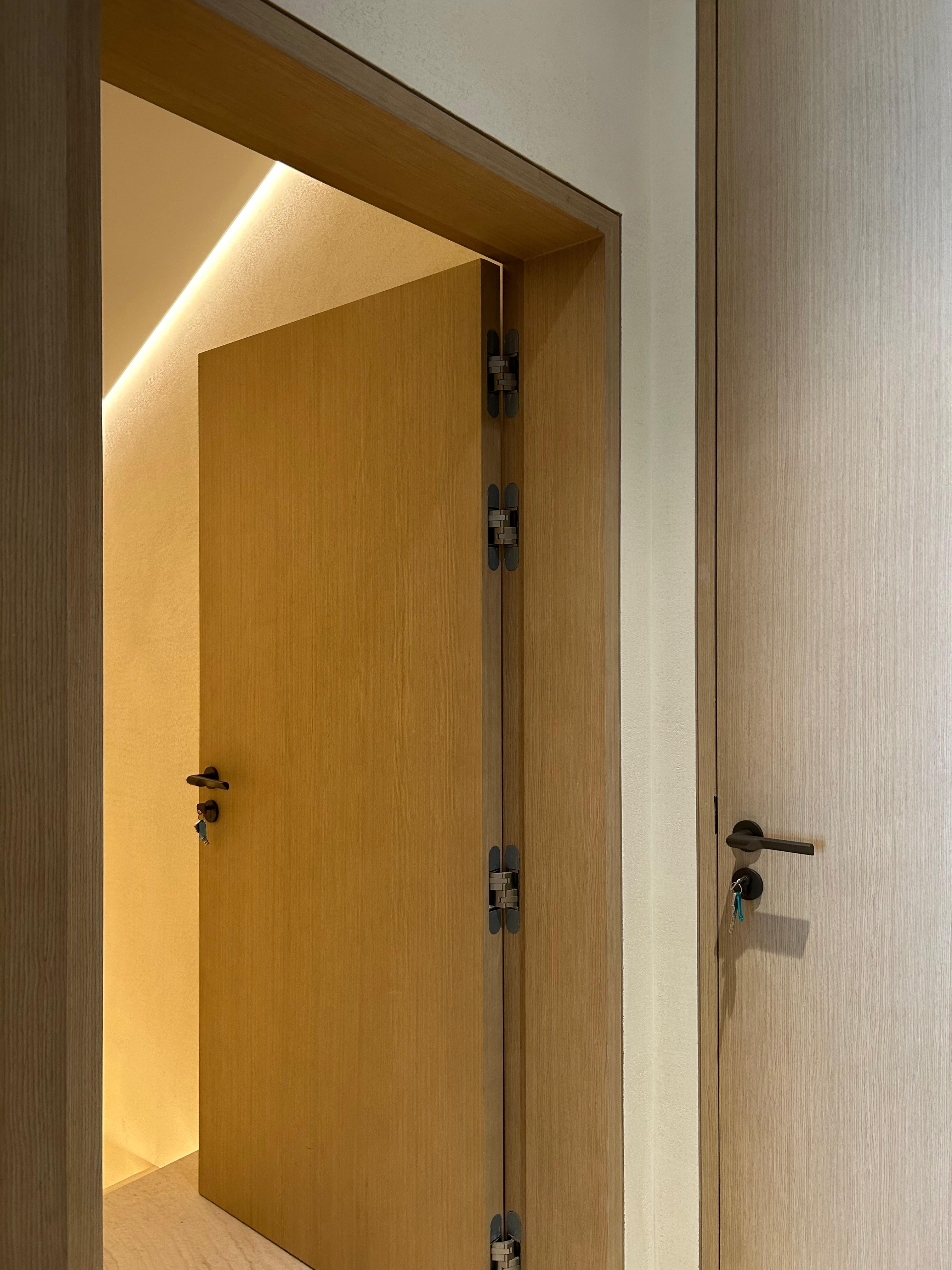 Bespoke wood veneer door with concealed hinges installed by Mistry Interiors