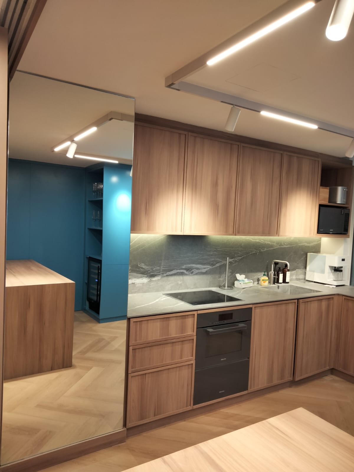 Bespoke kitchen with wood cabinetry and stone worktop by Mistry Interiors